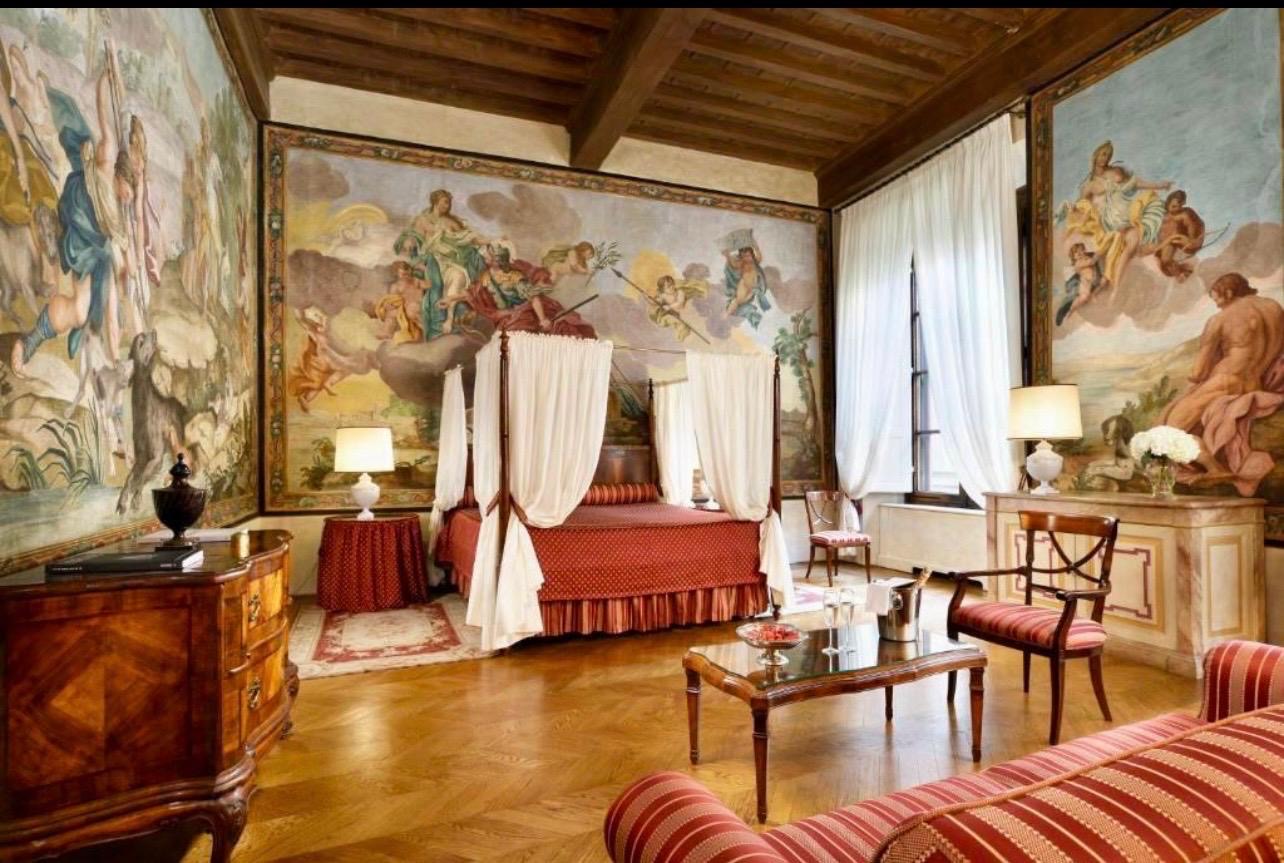 Stanza affrescata di Palazzo Niccolini con letto a baldacchino e pareti dipinte a tema mitologico