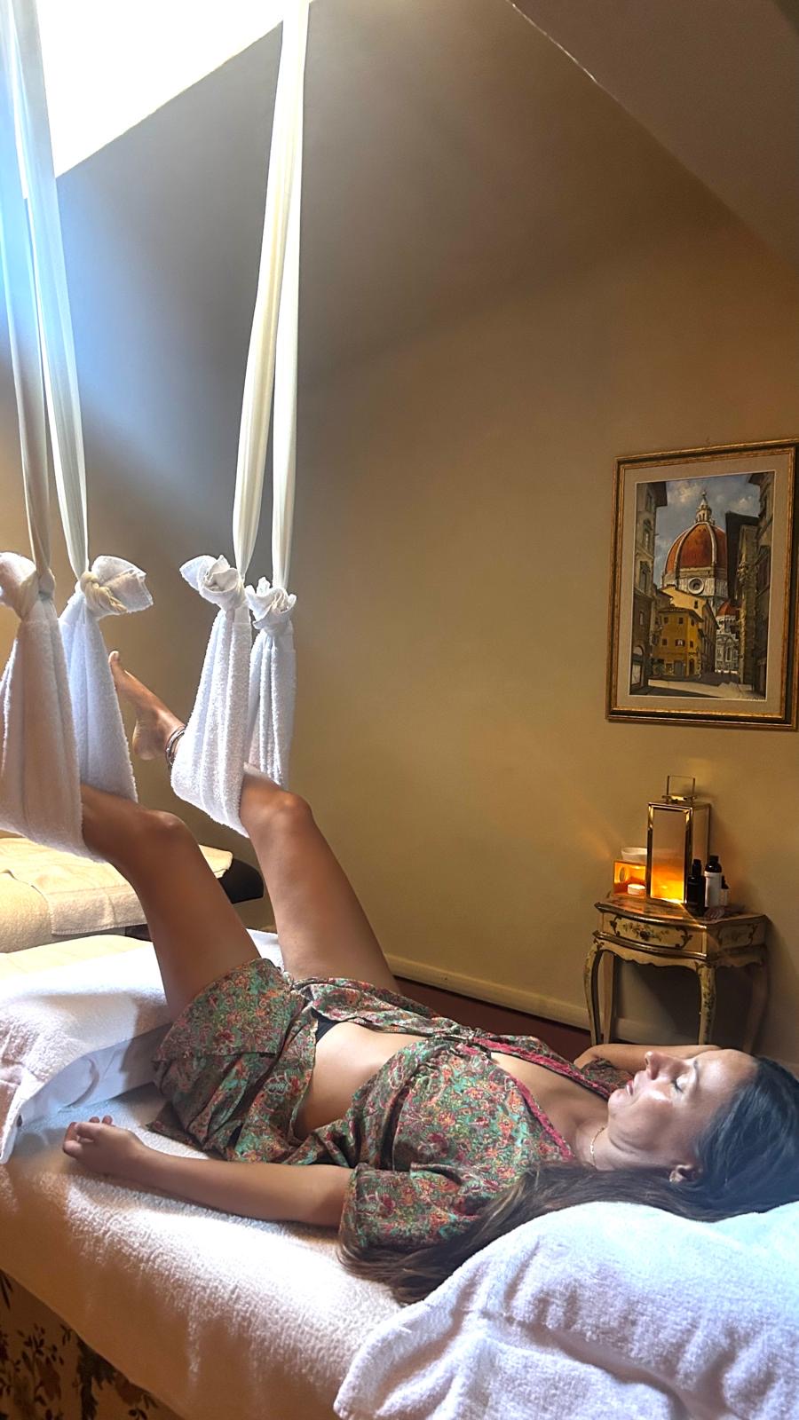 Gambe sollevate e avvolte in teli bianchi sospesi durante un trattamento